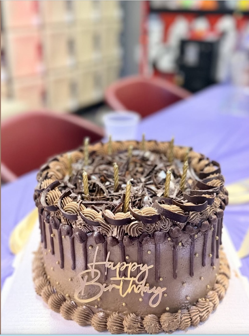 Chocolate birthday cake with candles and Happy Birthday lettering